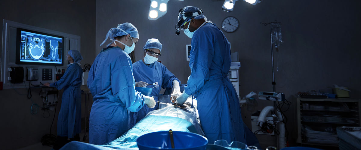 A team of surgeons performing surgery in an operating room who are working with a focus on incision care so the patient has healthy postoperative incisions.